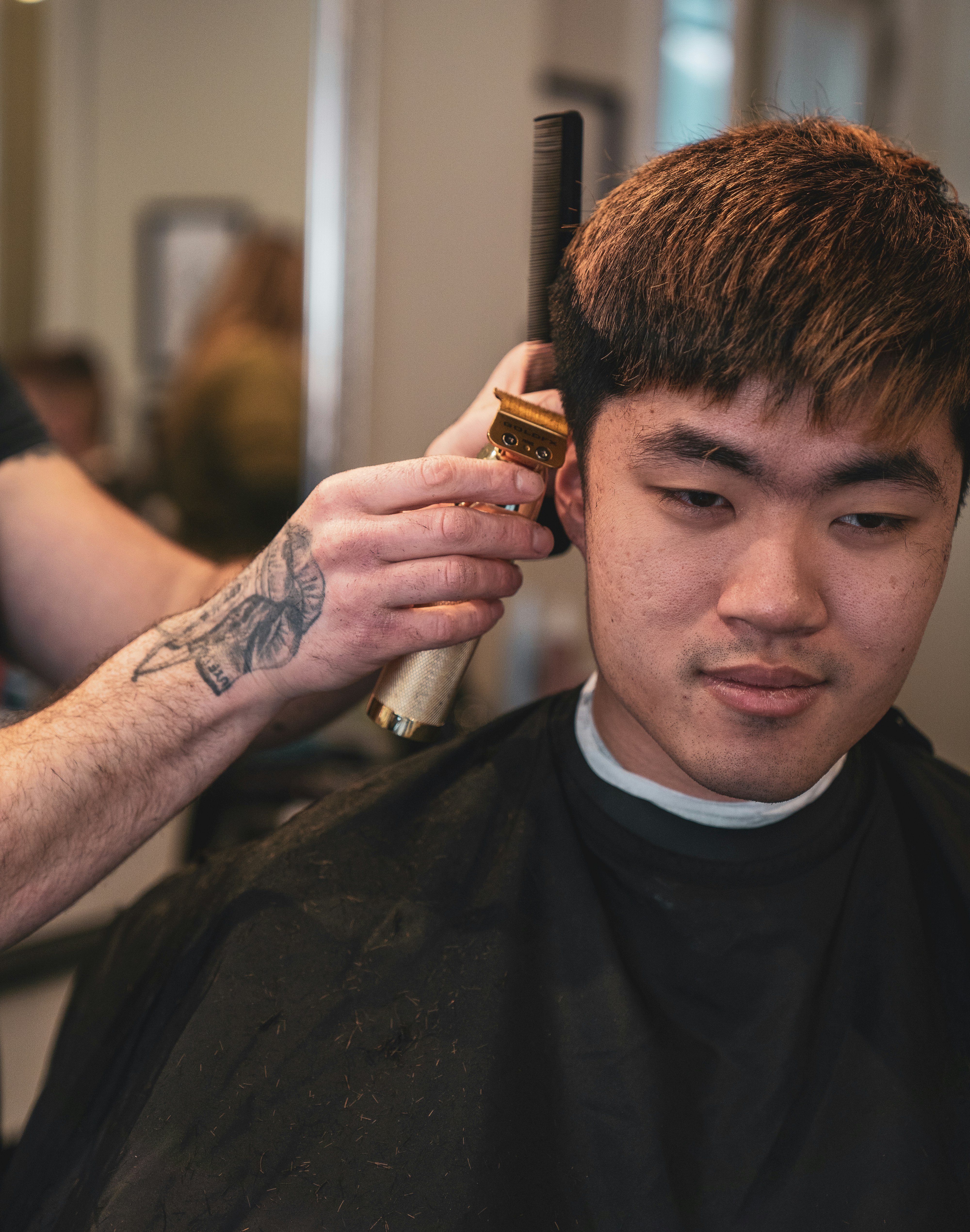 a man getting his hair cut by a barber