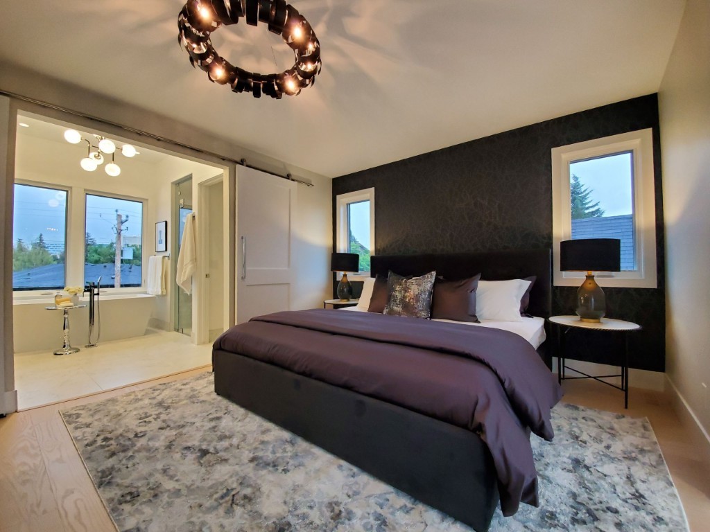Image of Luxurious primary suite with dark accent wall, modern furniture, and spa bathroom by KHD Homes.
