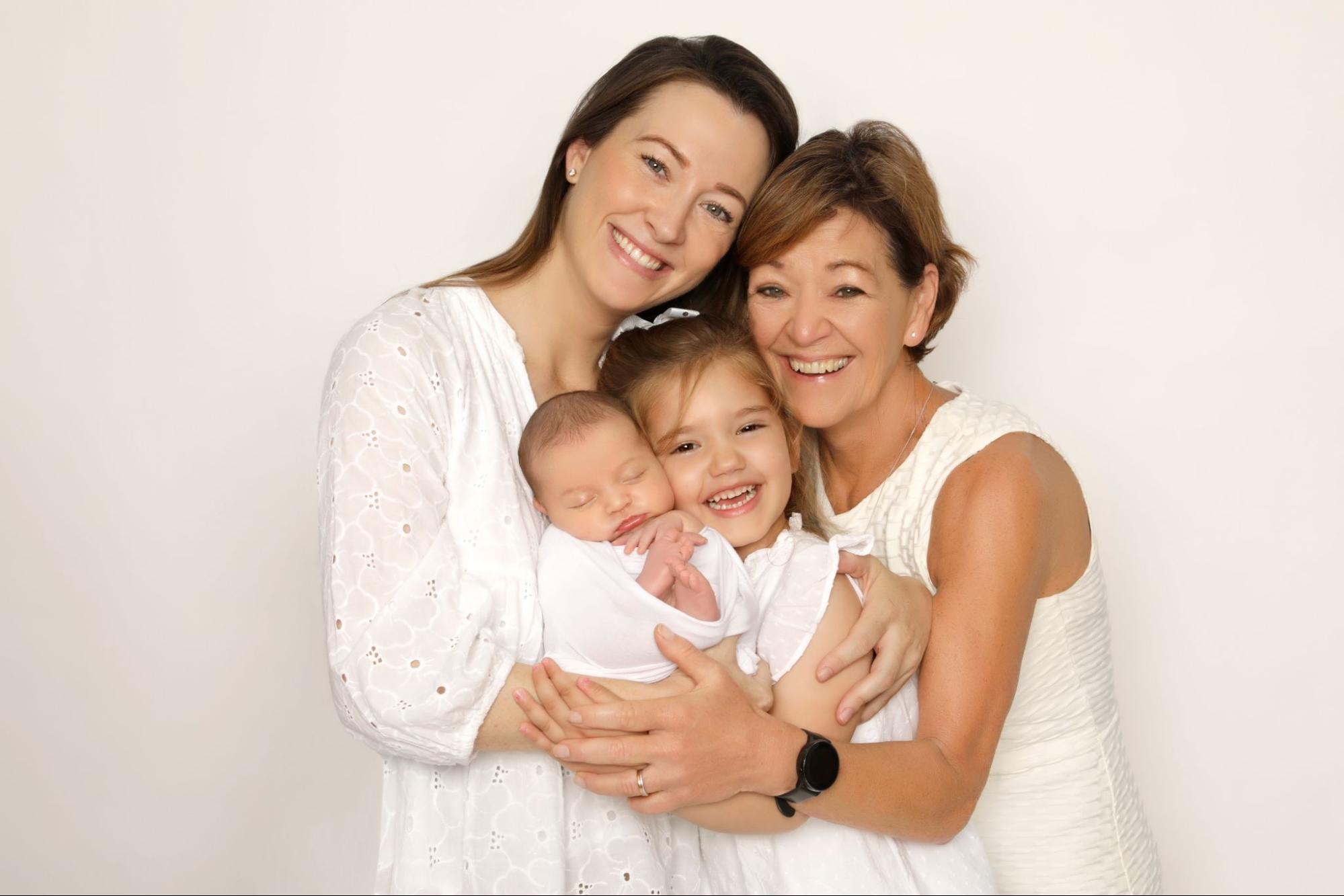 A glowing, joyful family photoshoot of four members in white, beautifully captured by Mahvin Photography in Dubai, UAE.