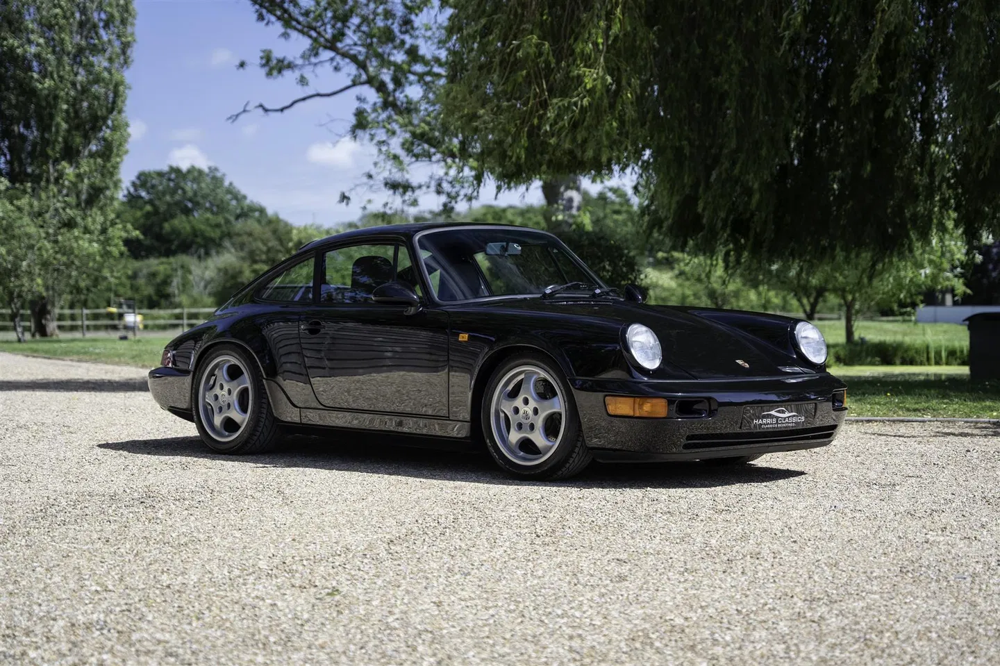 Front three-quarter view of the black 964 RS on a country driveway