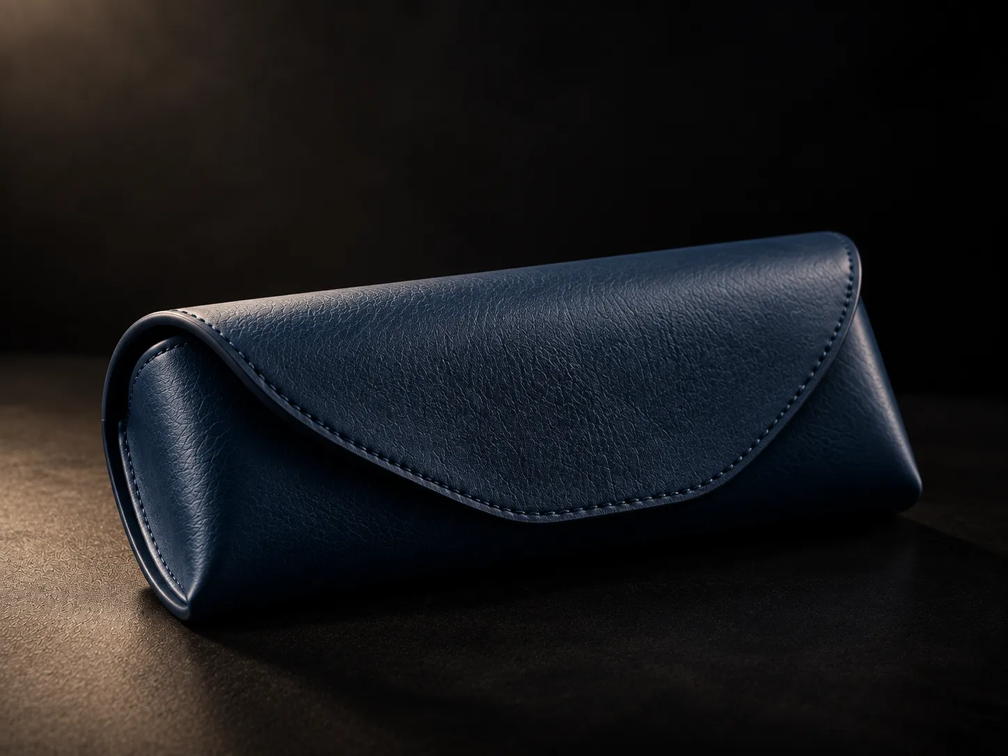 Astuccio per occhiali IDIA in pelle blu, fotografato in studio su fondo scuro con design essenziale ed elegante. Anche l’astuccio può accompagnare il percorso di personalizzazione degli occhiali su misura IDIA di Ottica Dentella ad Ancona, completando il progetto con un accessorio coordinato alla montatura e all’identità della persona.