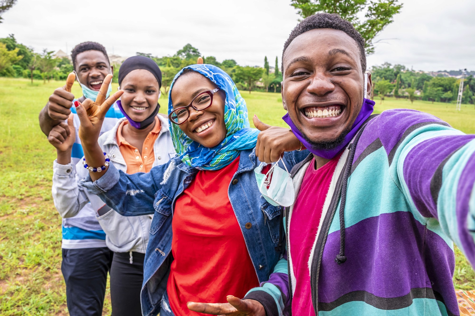 five children smiling while doing peace hand sign