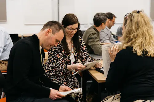 Some people looking at a book together.