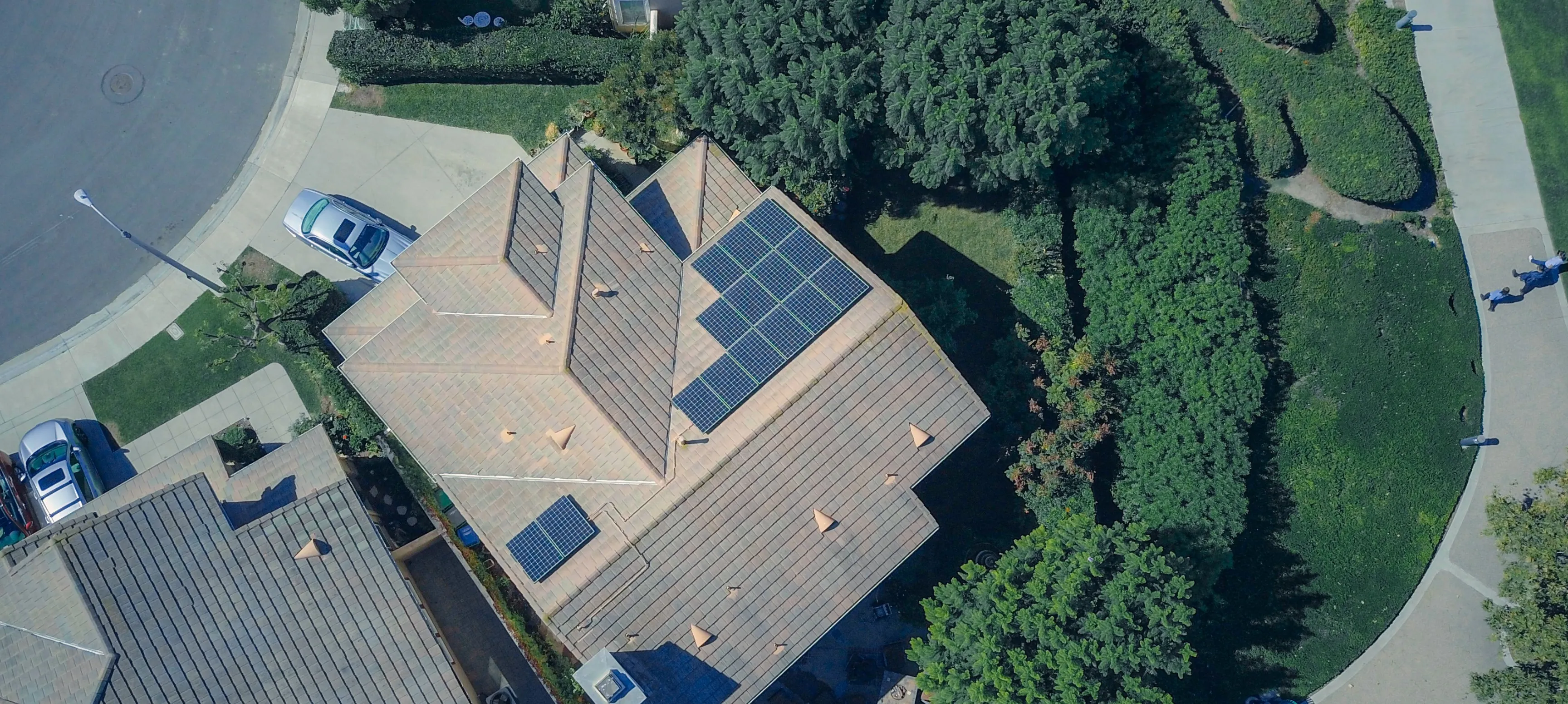 A drone photo of a neighbourhood featuring a home with solar panels on the roof.