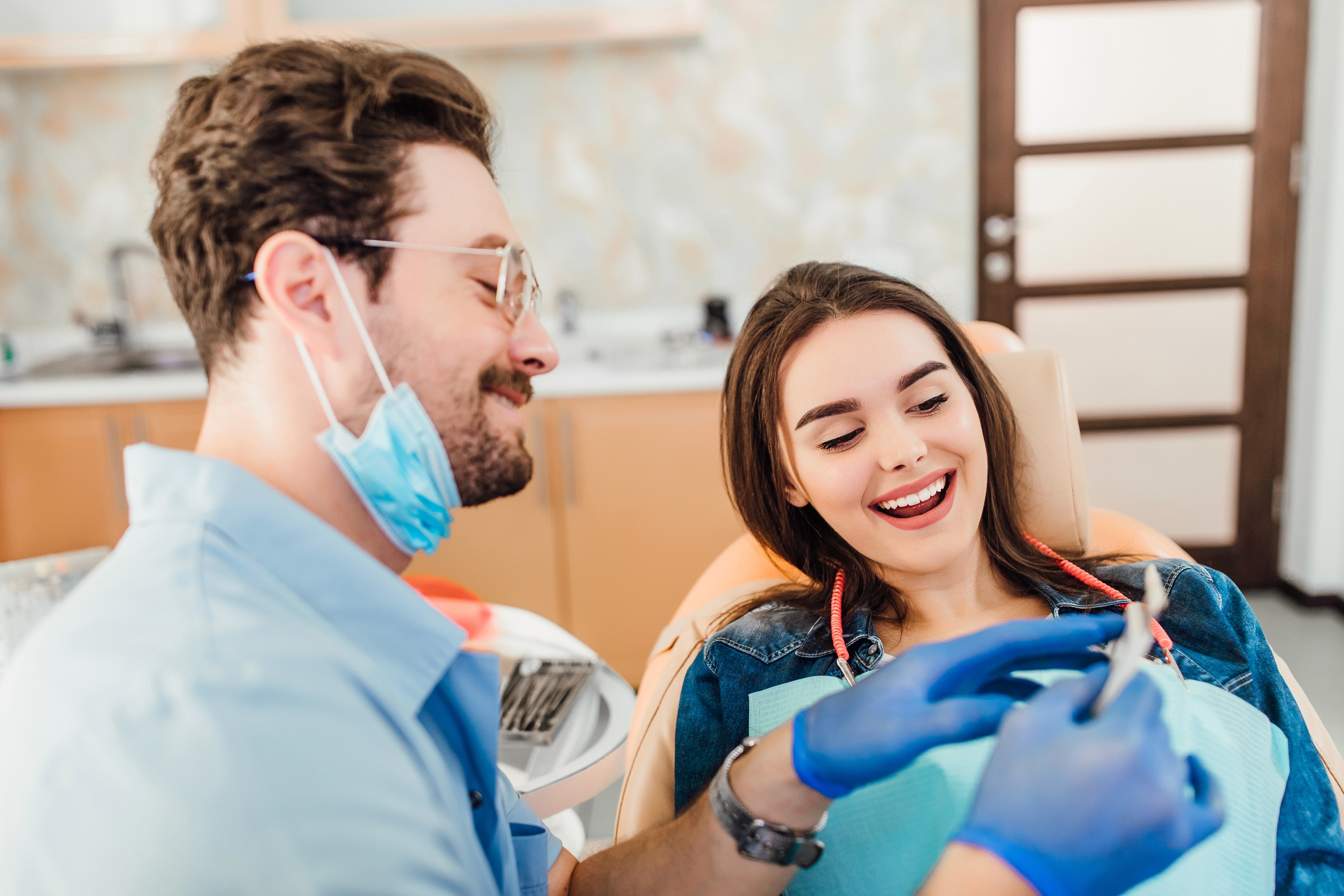 Dentist explaining treatment to a smiling patient during a dental visit