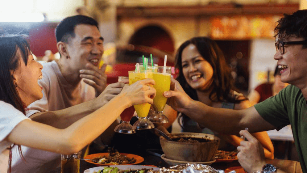 Empat orang pelanggan kelihatan gembira makan di salah sebuah restoran di Malaysia.