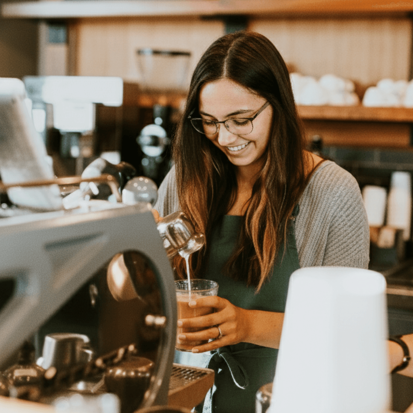 Barista versant du lait dans un café.