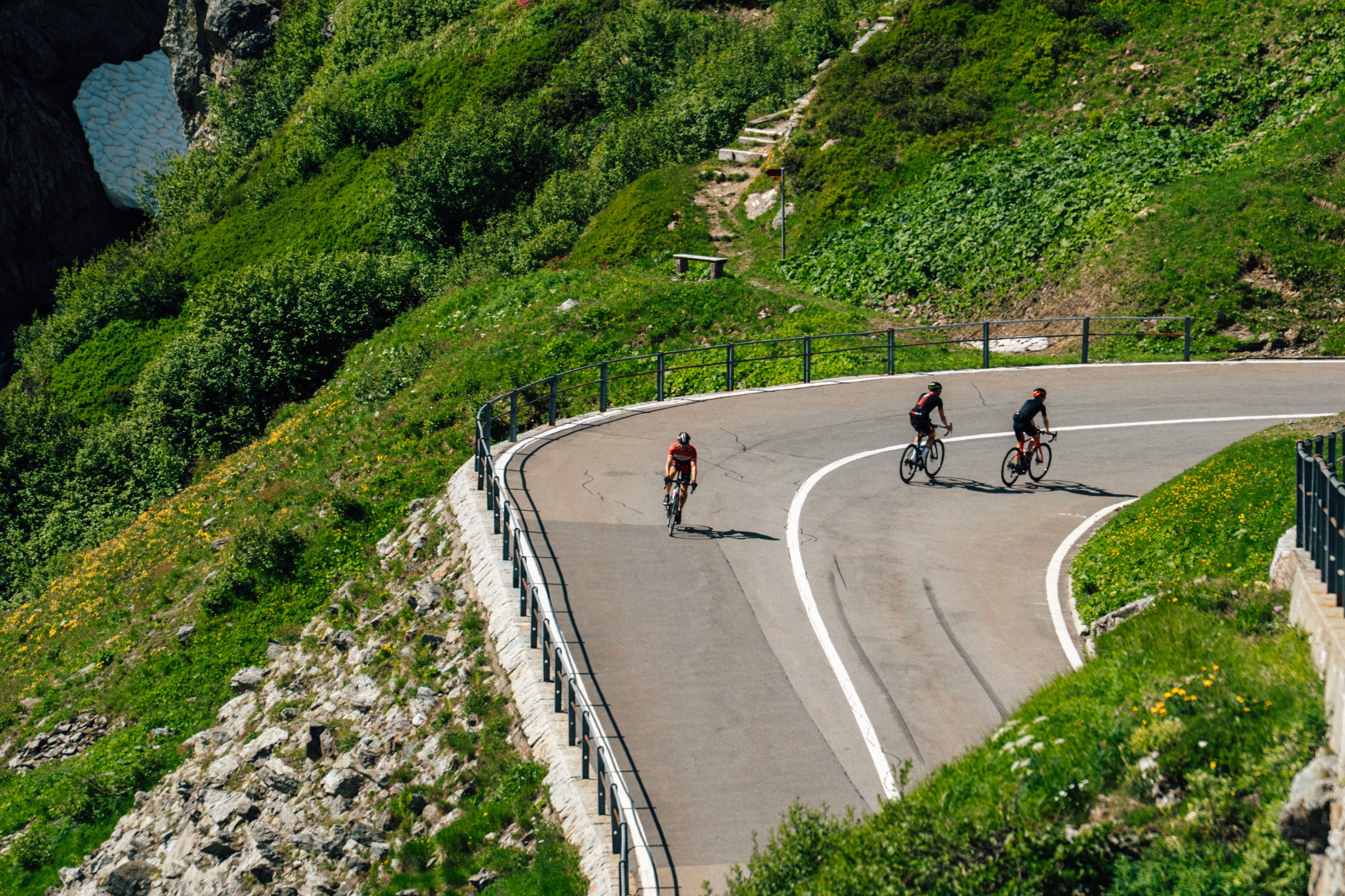 Three cyclists riding the Swiss Alps