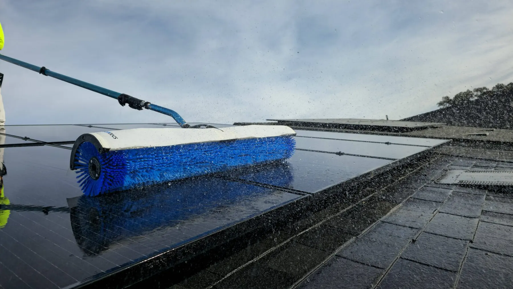 Blue rotary brush cleaning wet solar panels | Premier Solar Service, serving Fresno, CA
