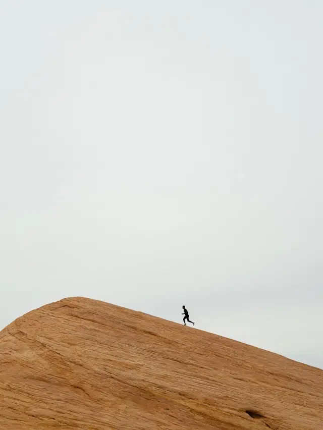Man resting with eyes closed in a dimly lit gym after physical effort