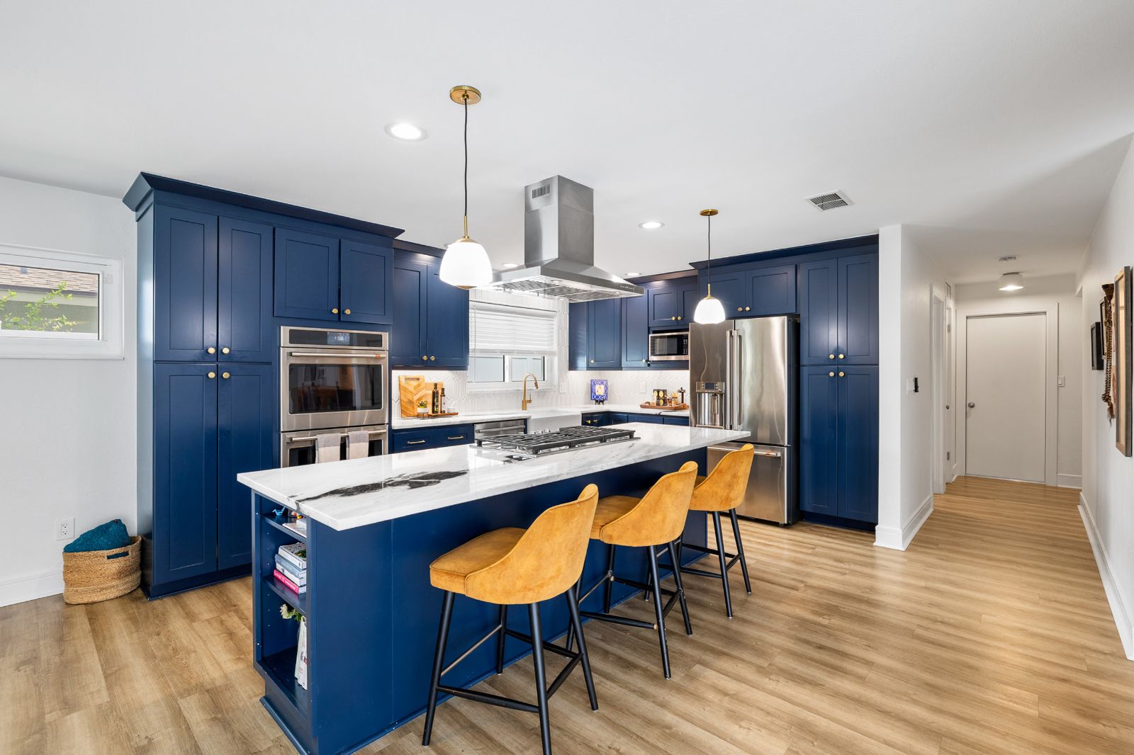 Navy and brushed gold kitchen with marble island