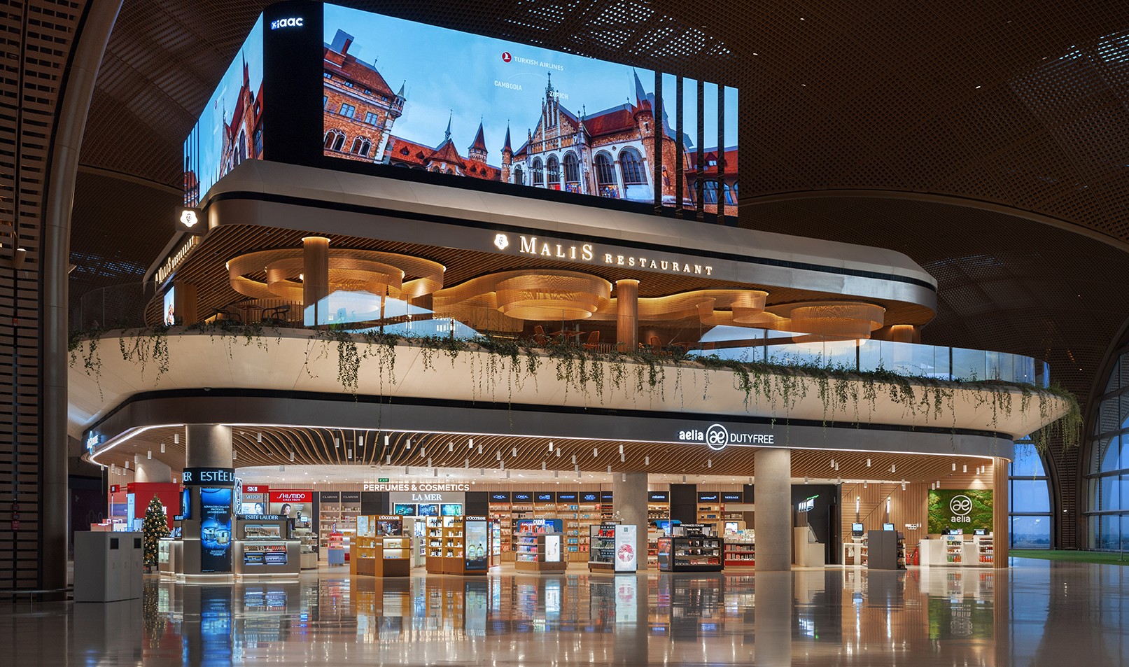 Architectural view of the elevated Malis Restaurant at Techo International Airport positioned above the Aelia Duty Free retail zone showcasing the seamless integration of hospitality and luxury retail within the terminal
