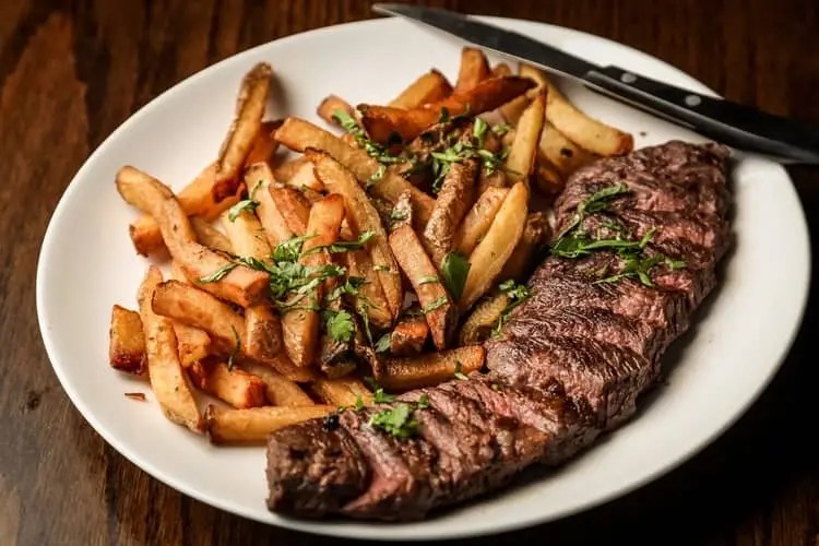a dish of steak and French fries