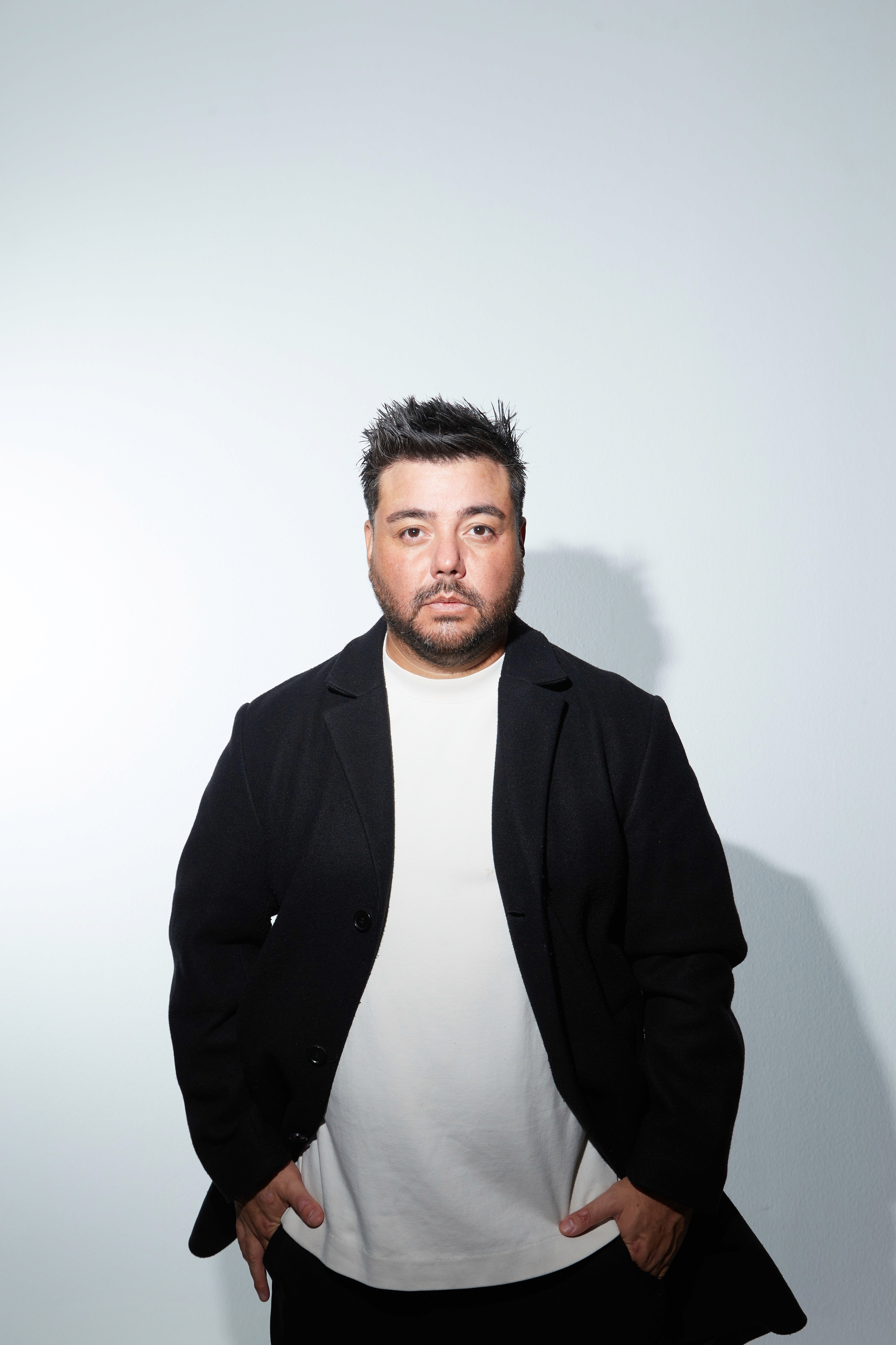 Young woman in a white shirt with a colorful gradient print, against a plain background.