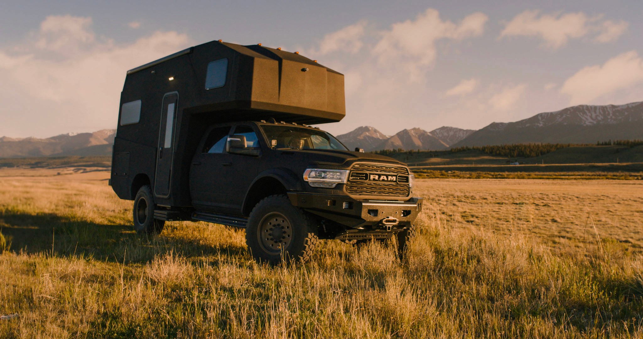 27North adventure vehicle in a grass field in front of mountains