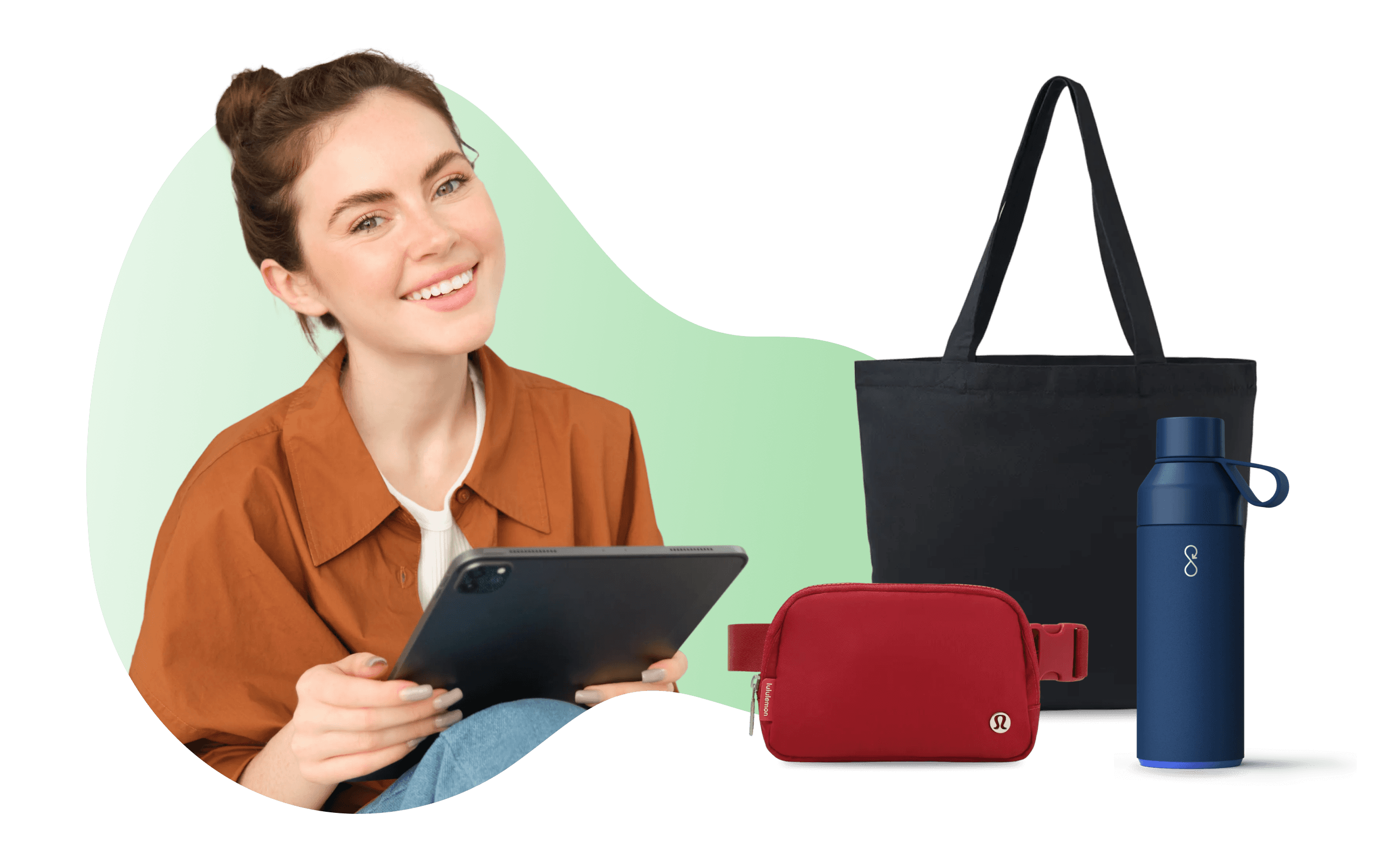 A woman smiling, holding a tablet. Beside here, there are a tote bag, a crossbody bag, and an insulated tumbler.