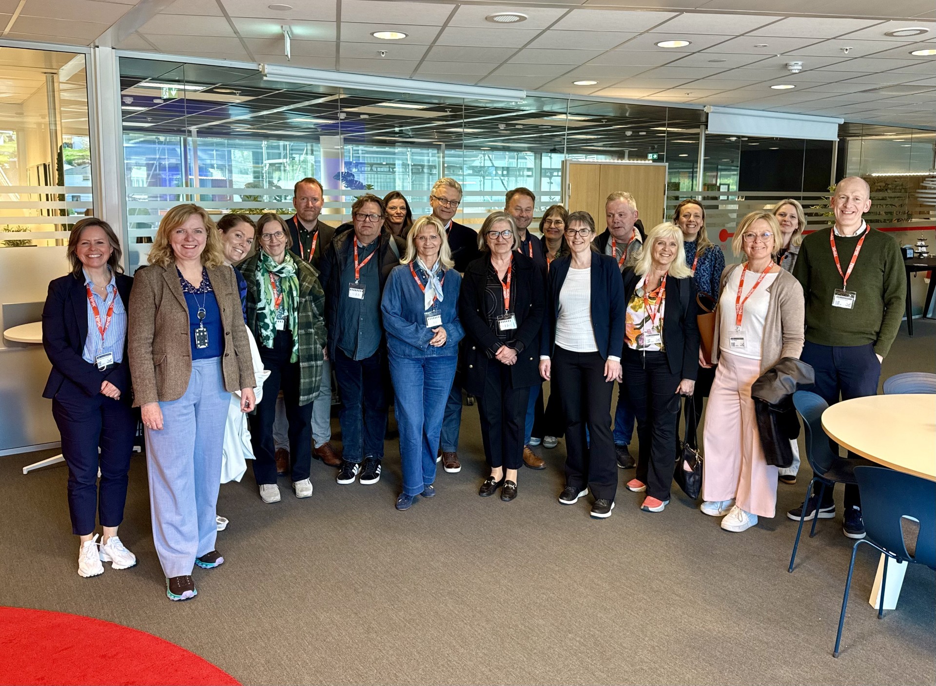 A person wearing a virtual reality headset stands in front of multiple screens, engaged in a digital experience.