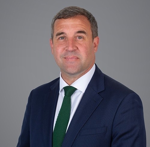 Man in a dark suit and green tie