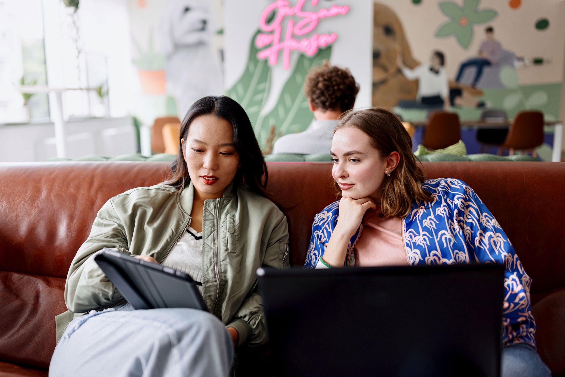 two women working in amodern office on laptop