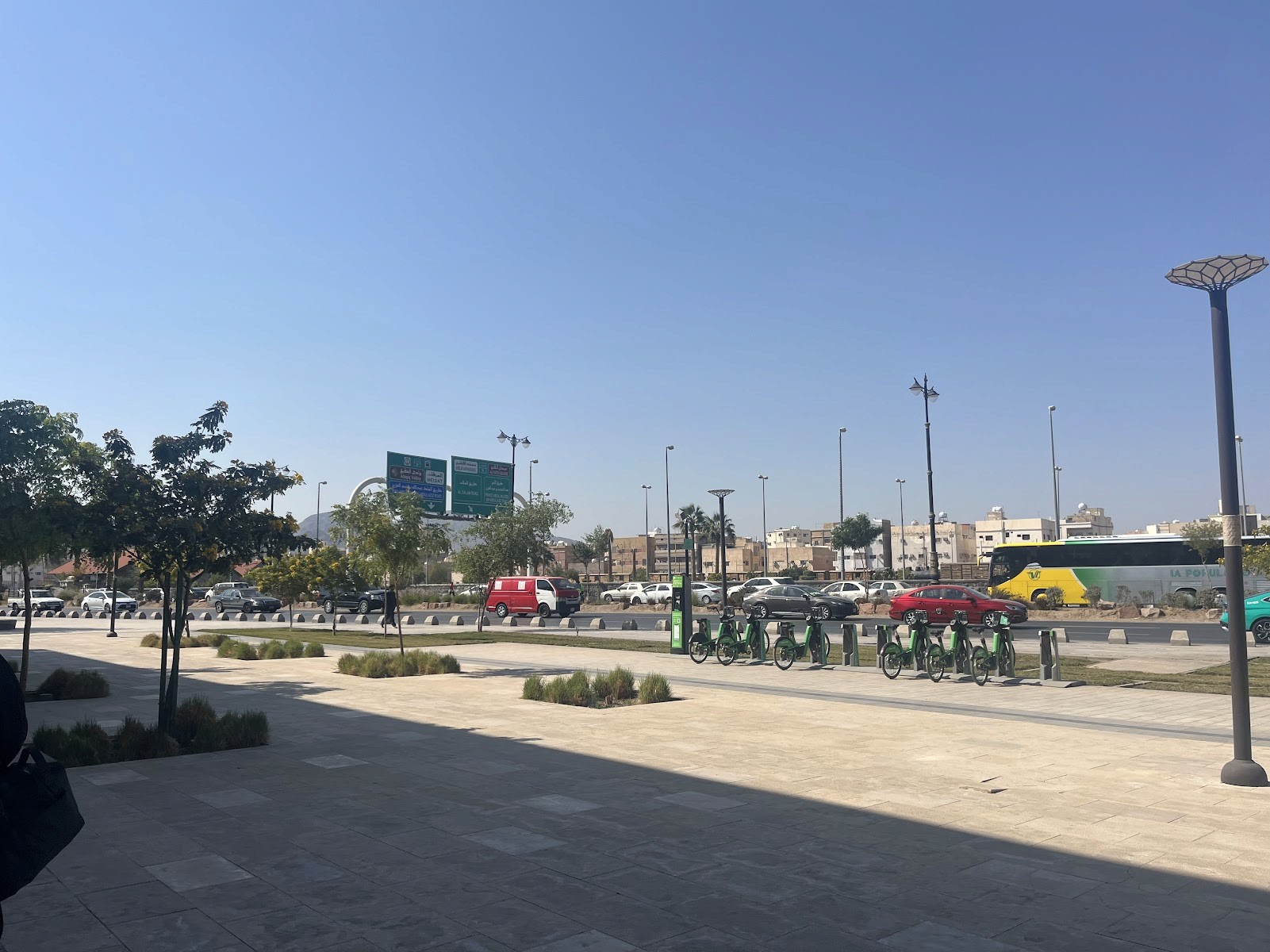 Modern home office setup with a monitor, ergonomic chair, keyboard, and indoor plants near a window with blinds.