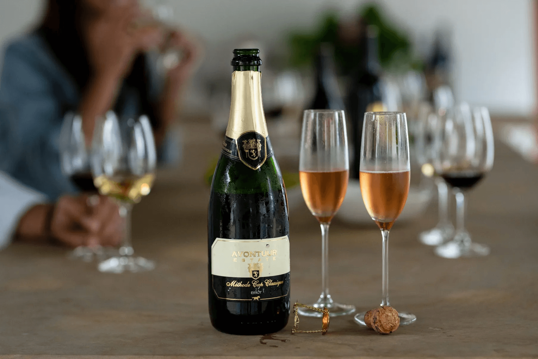 Bottle of wine with wine glasses half full on a table at Avontuur Wine Estate