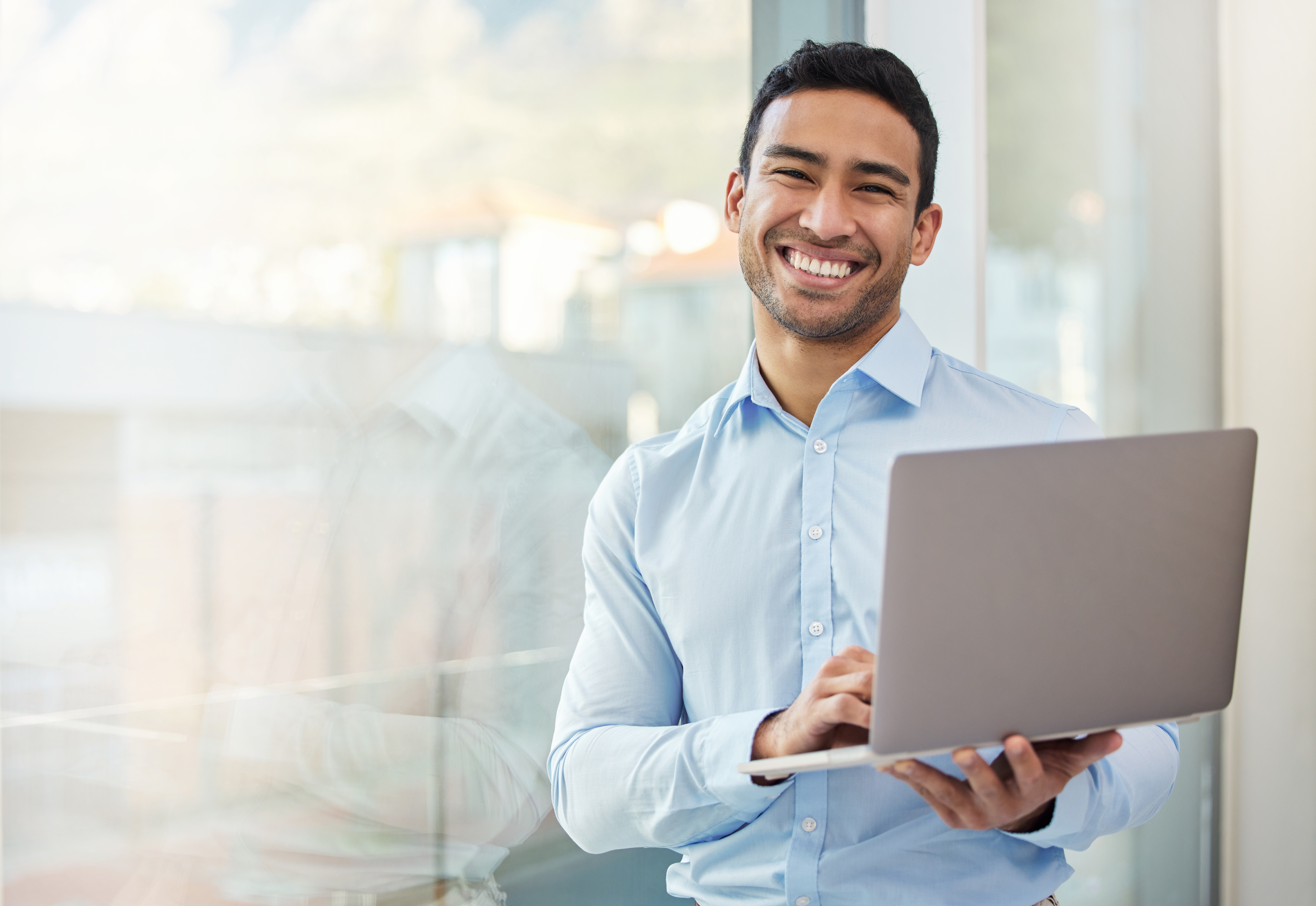Smiling professional using a laptop in a bright office