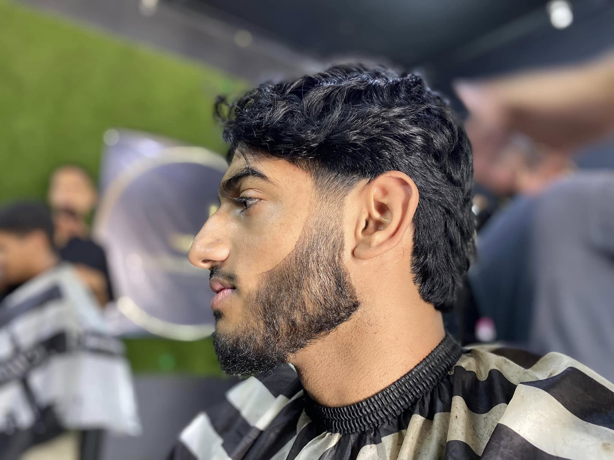 Someone sitting with a beard and fade cut at the diamond standard