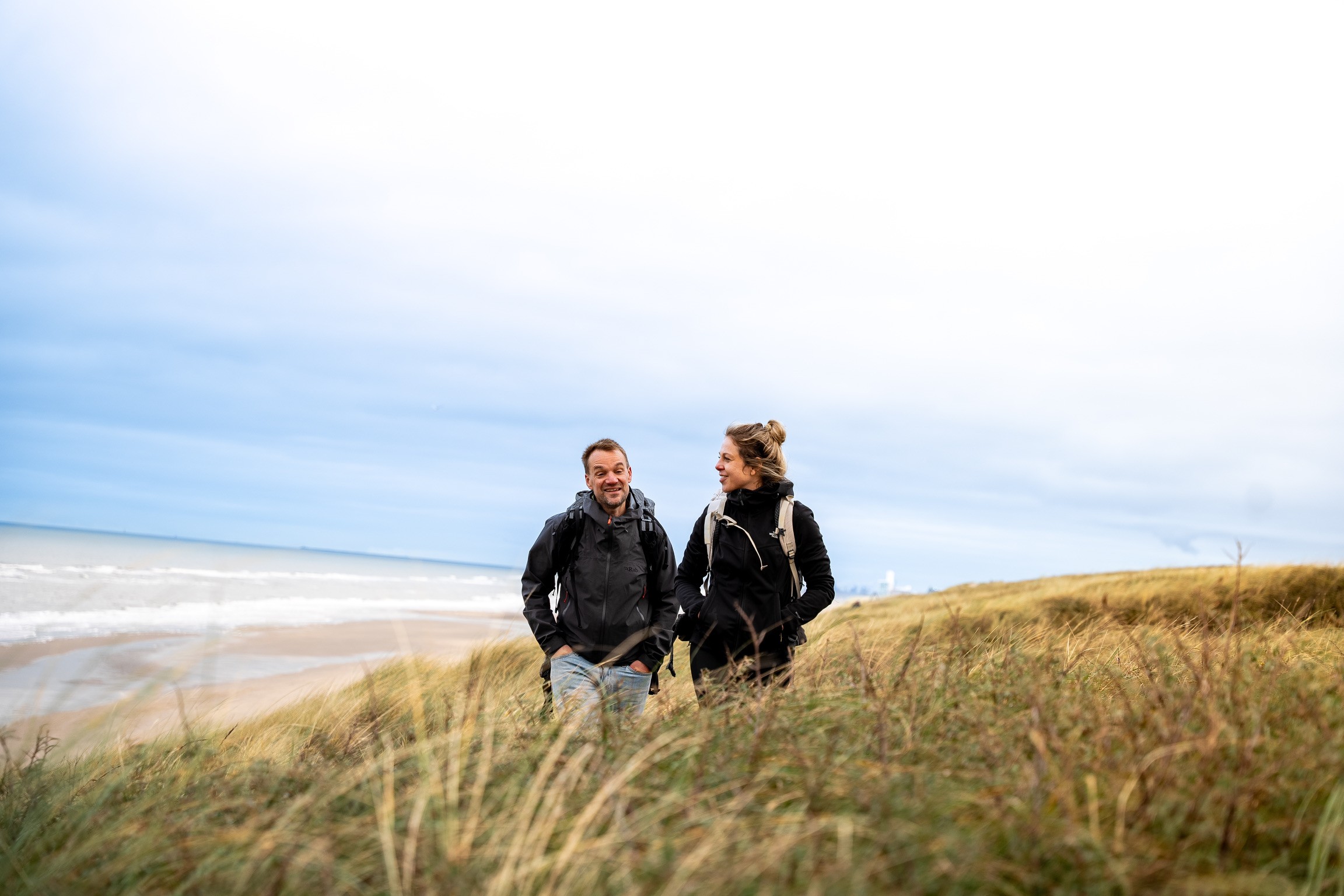 Two people having conversation next to the sea