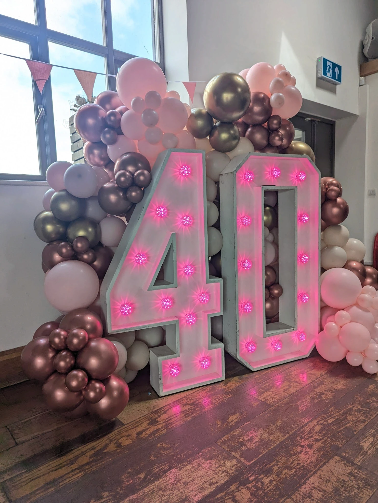 Pink 40th light-up numbers with balloon clusters in brown, rose gold, and pink tones