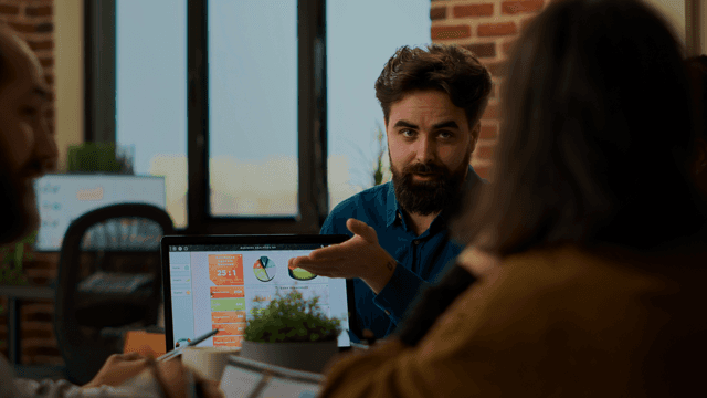 Photo of a man demonstrating something on the computer