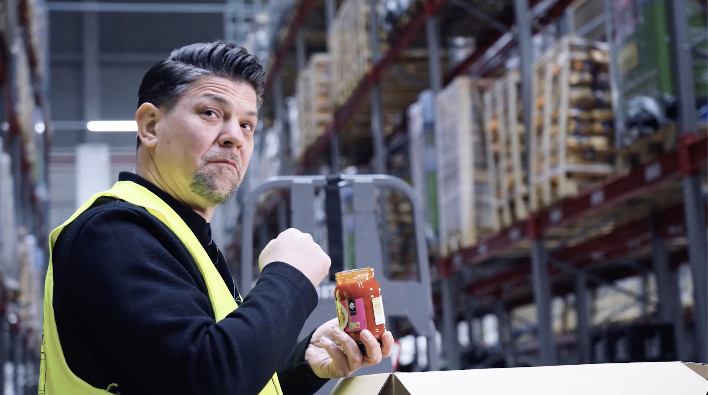 Tim Mälzer presenting a food product during a branded content campaign shoot.