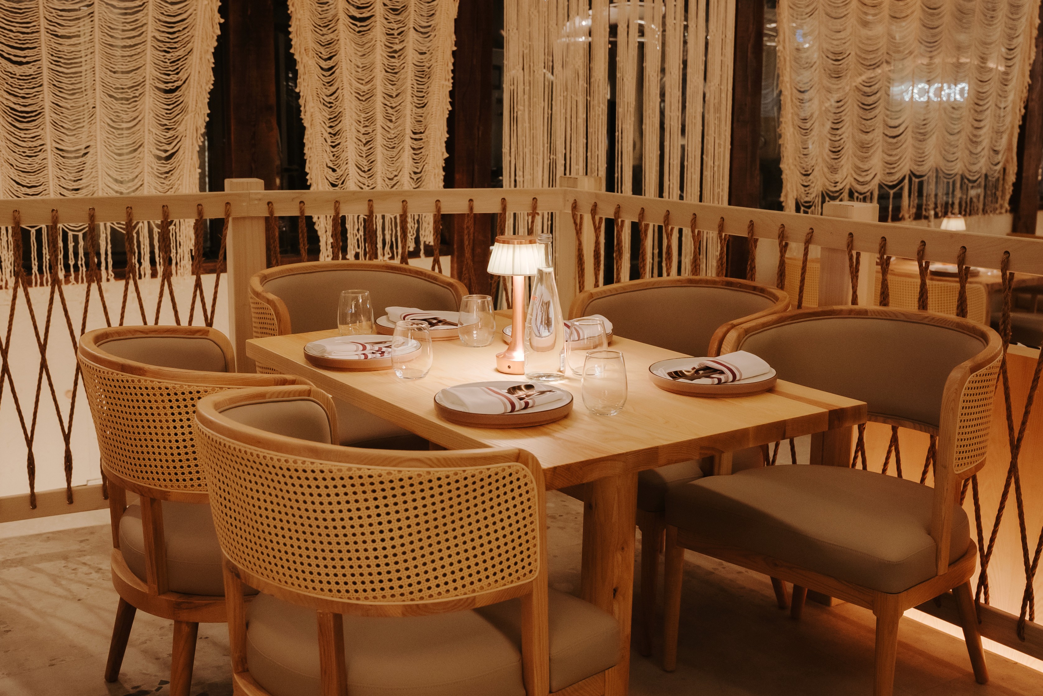 Elegant private dining seating at Dhoom Toronto with handcrafted wooden furniture, soft ambient lighting, and modern Indian hospitality aesthetics.