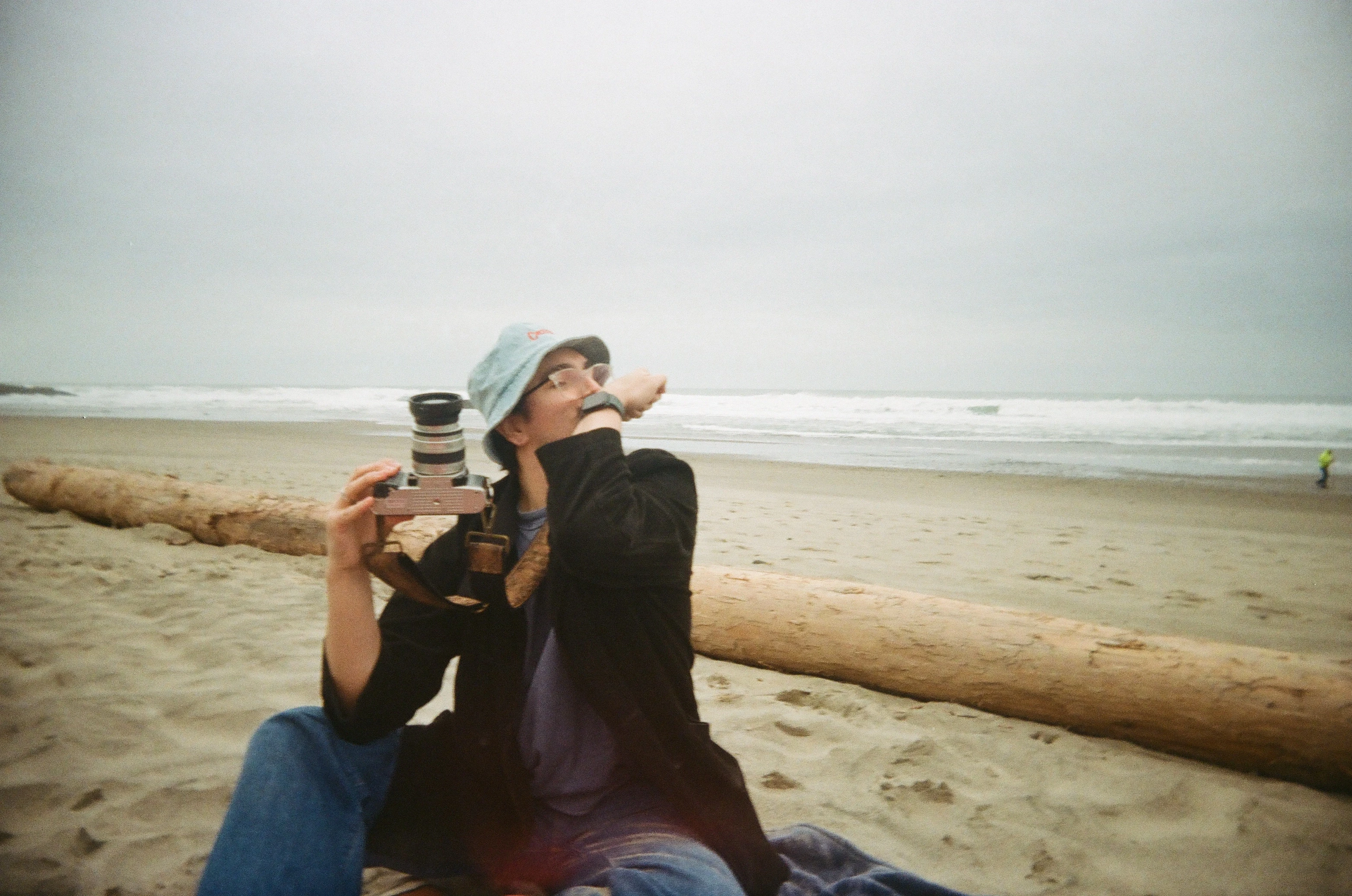 Alec Zamarripa holding film camera on Oregon beach