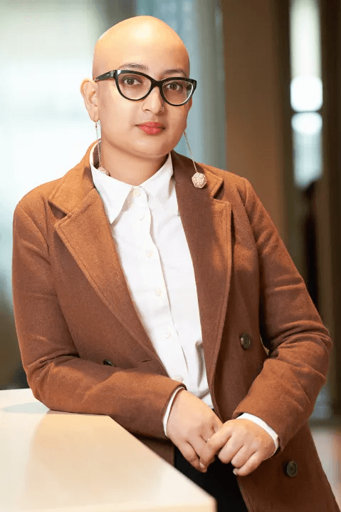 Close-up of a female tennis player wearing a visor, holding a racket with a ball.