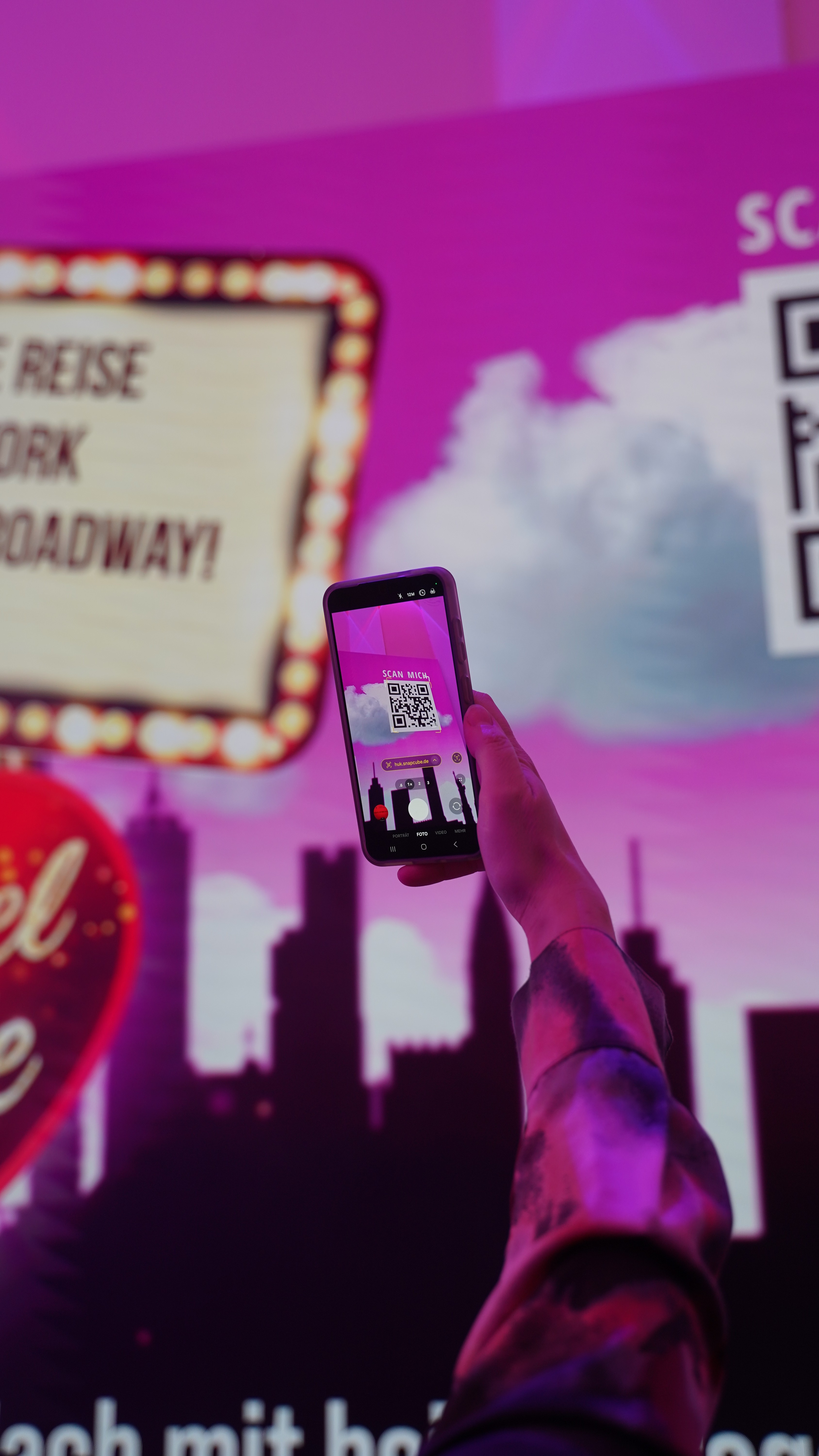 Besucher scannt einen QR-Code mit dem Smartphone, um die SnapCube GO Foto-WebApp zu starten.