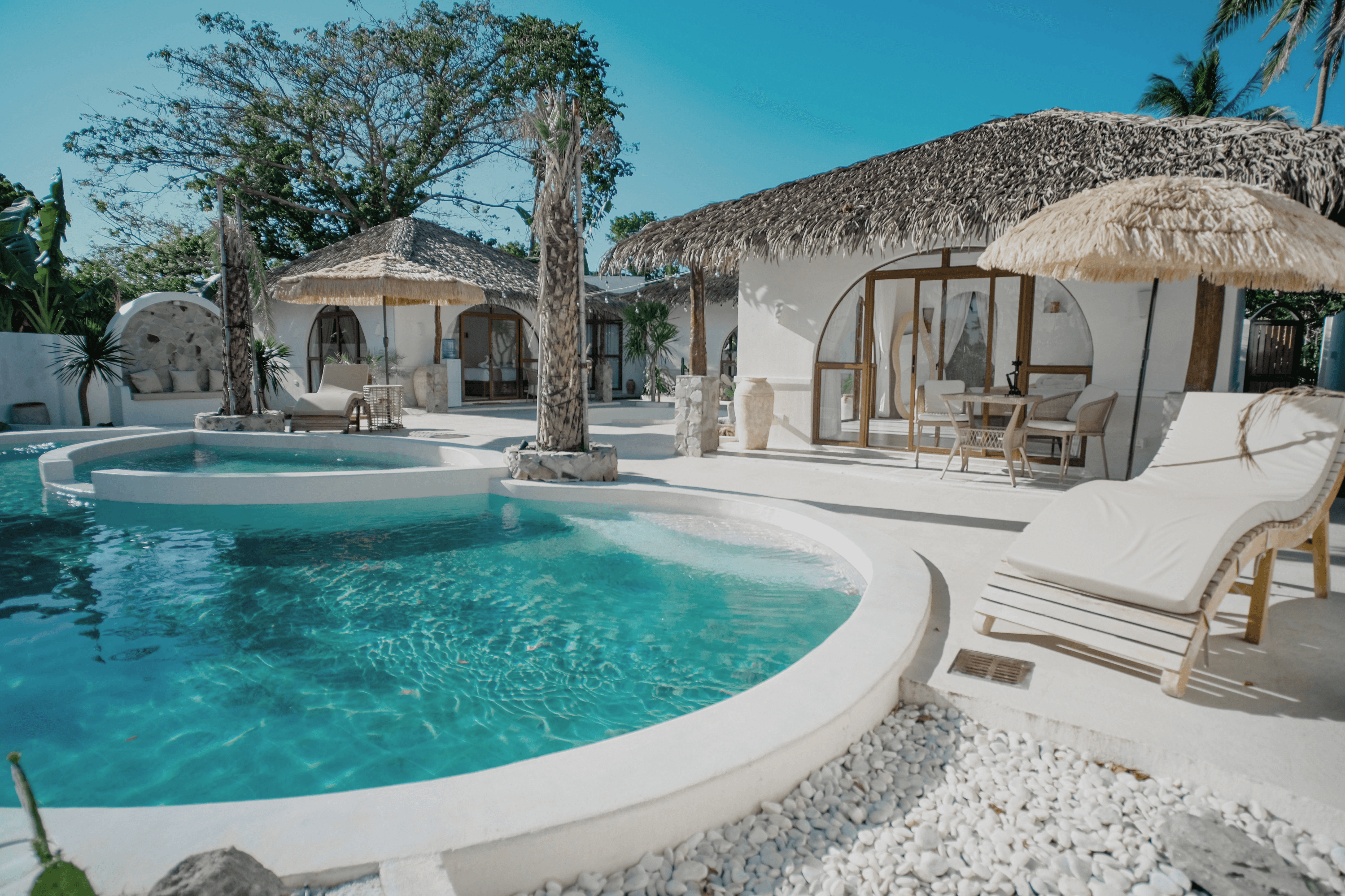 Luxury resort with pool and thatched roof bungalows