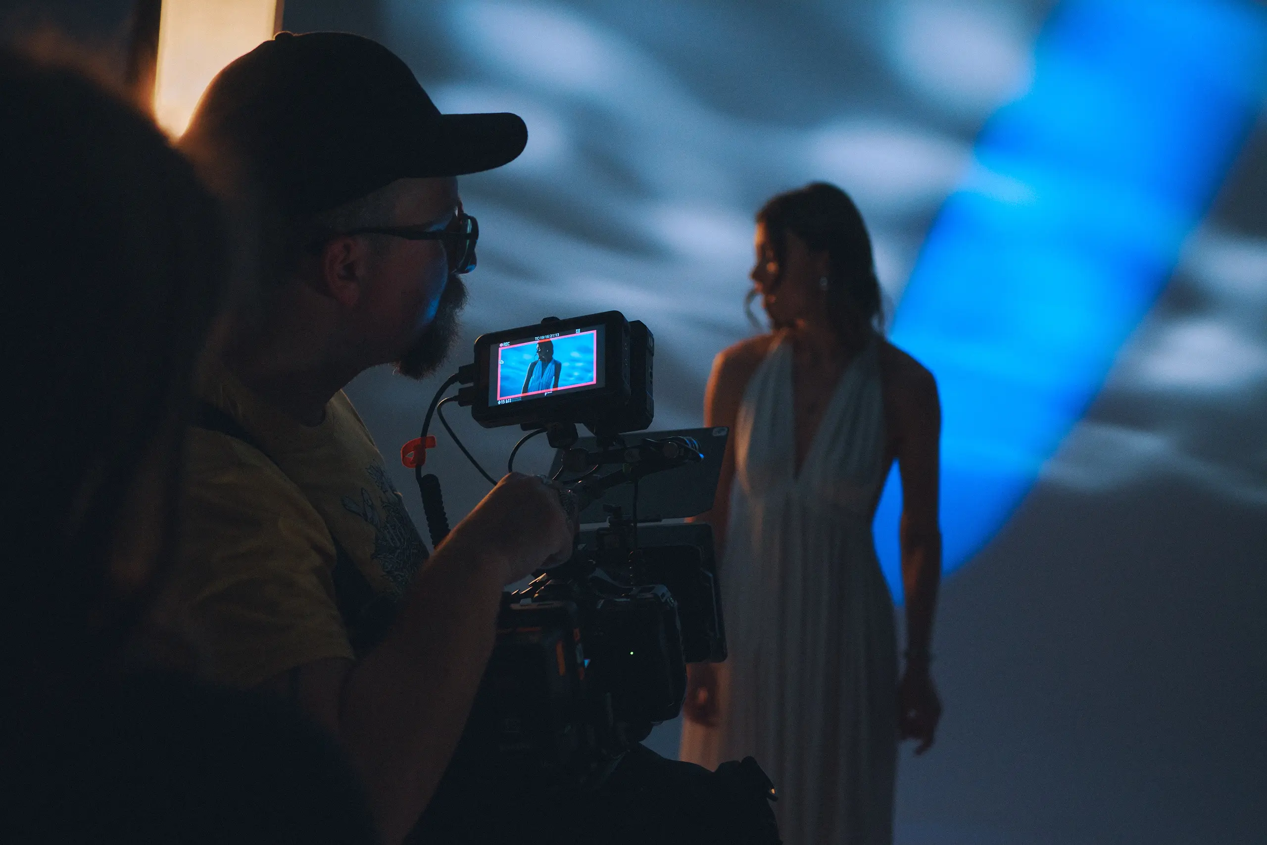 A man is holding a camera and filming a girl.