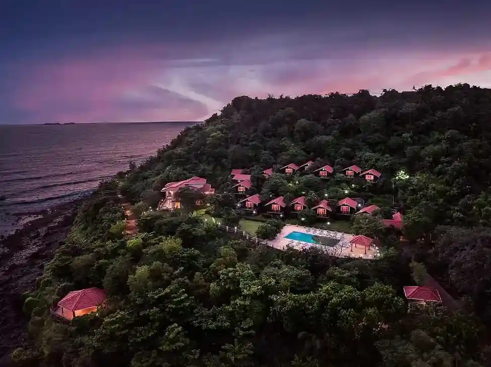 <img src="your-image.jpg" alt="Highland Sarovar Portico hotel surrounded by dense greenery, offering a serene and luxurious stay in Sindhudurg.">