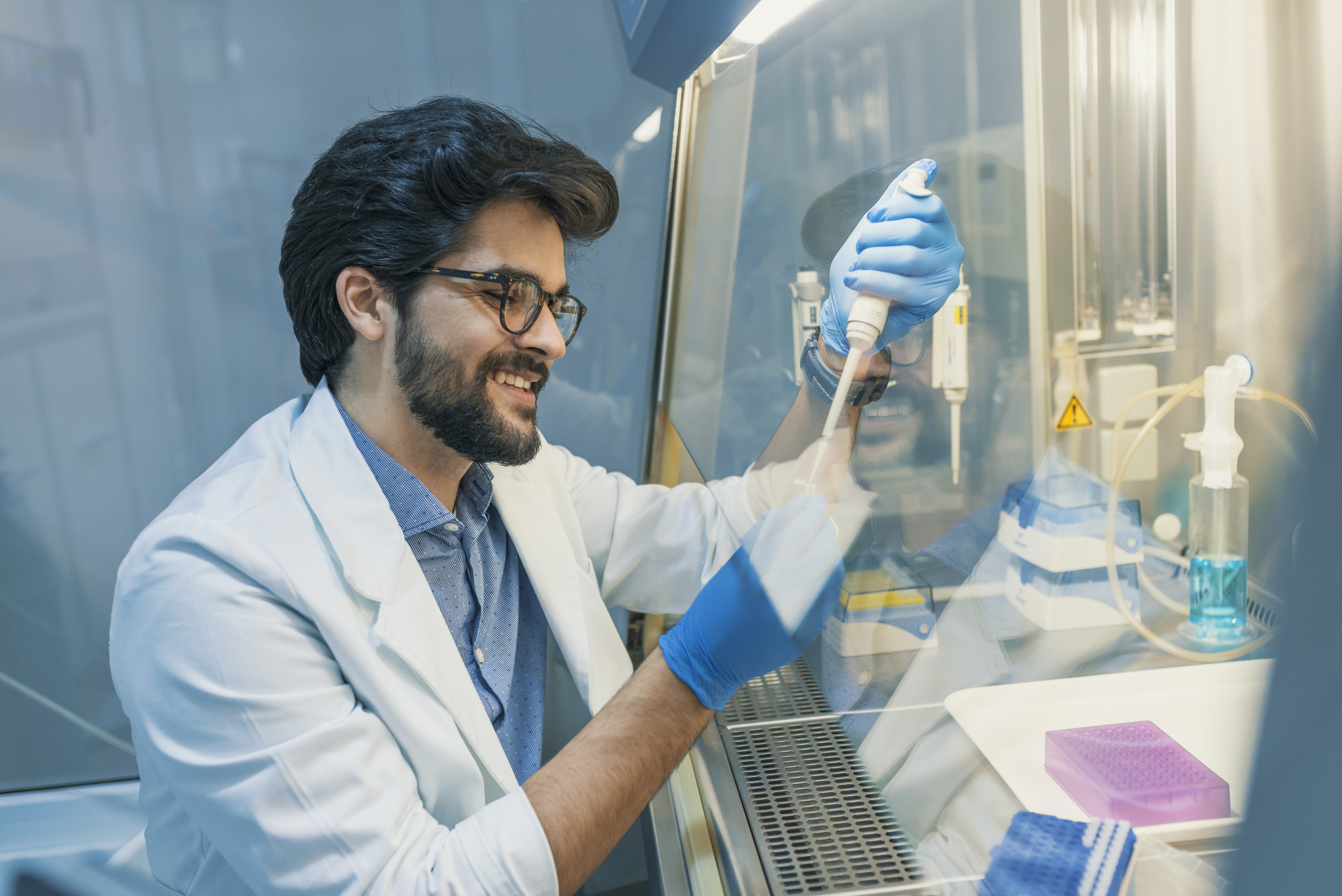 Bachelor of Medical Laboratory Technology A medical laboratory technologist using a micropipette to handle samples inside a laboratory workstation, representing the Bachelor of Medical Laboratory Technology (BMLT)