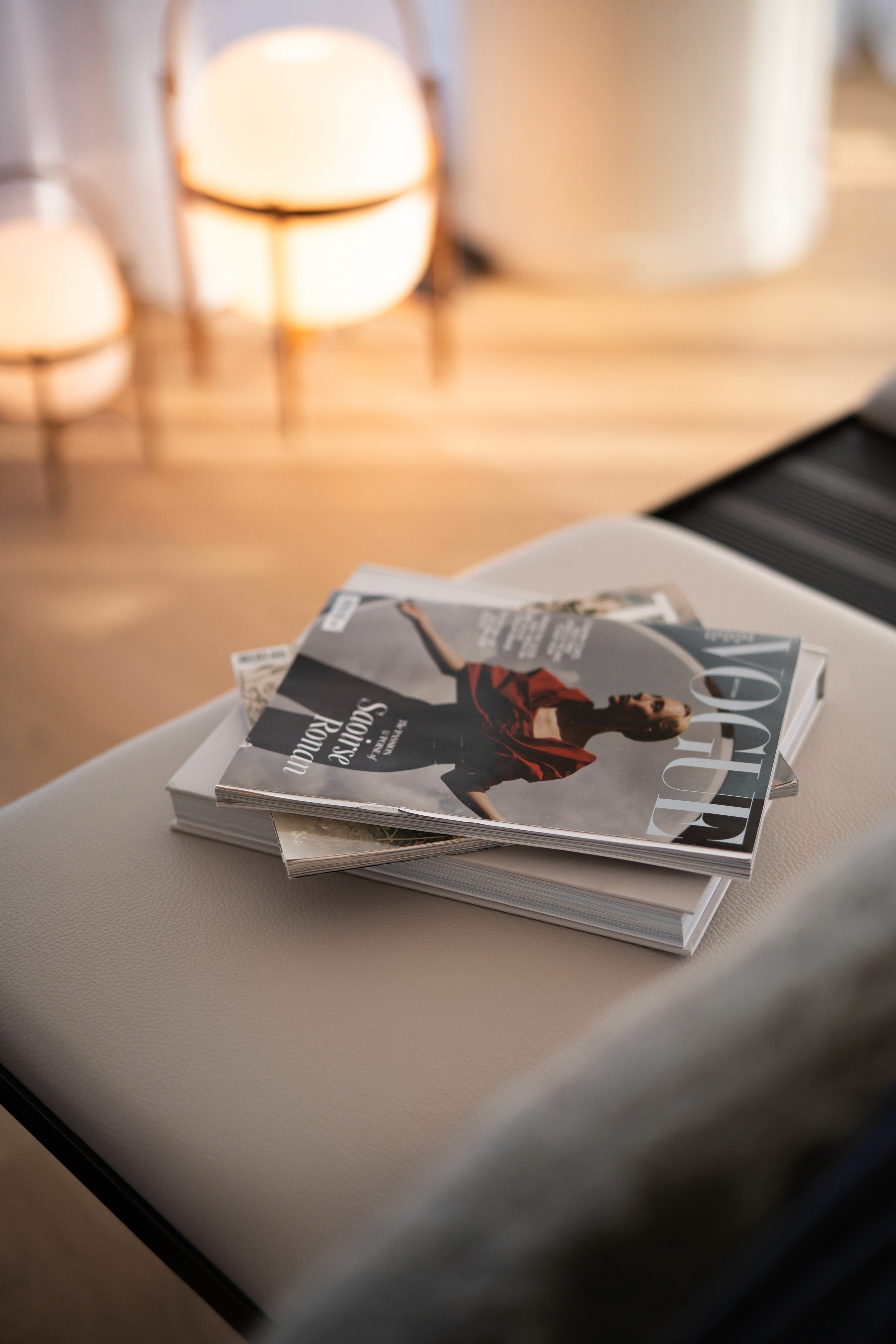 Revistas, incluida Vogue, sobre una mesa auxiliar