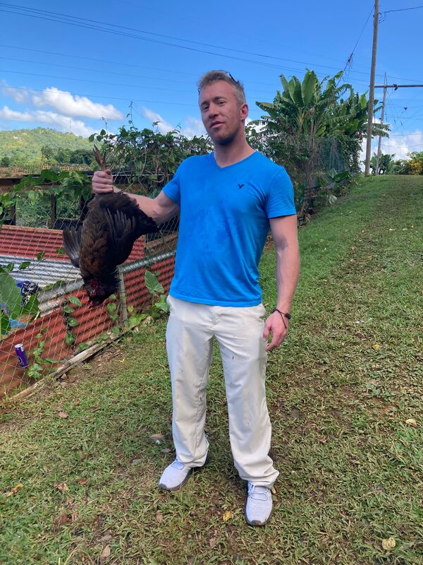 Filmmaker holding a chicken during production of Puerto Ricans on the Rise documentary, Puerto Rico