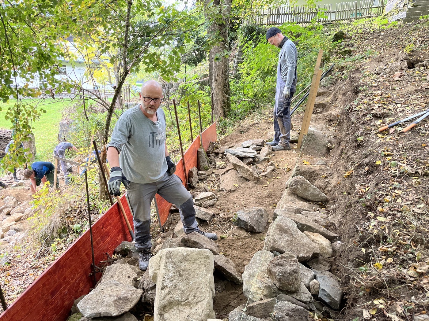 Teilnehmer beim Bau einer Stützmauer