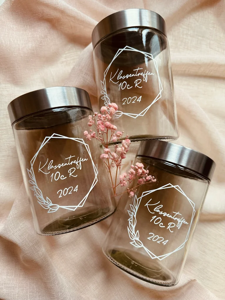 A couple in wedding attire walks hand in hand across a sunlit field.