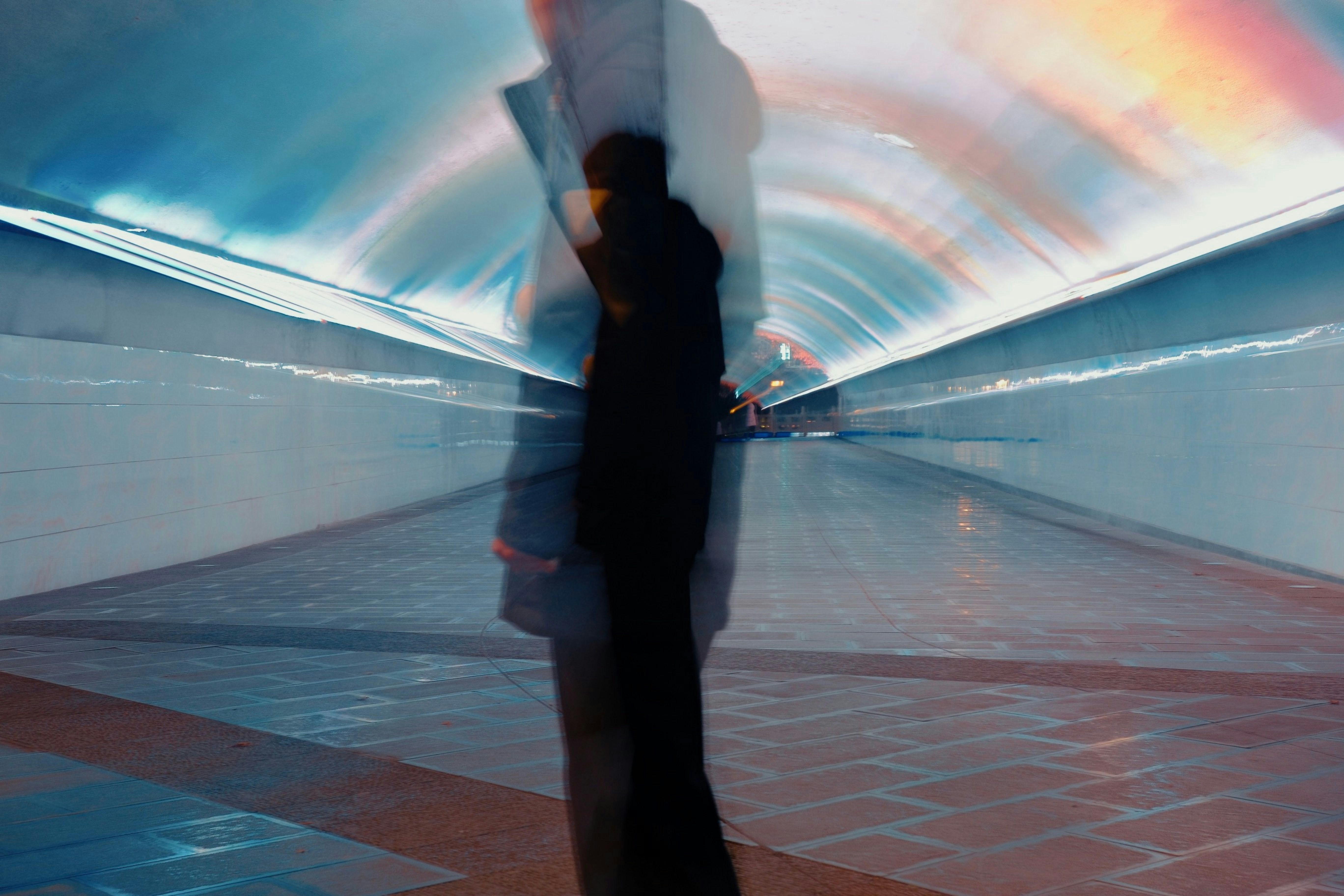 a blurry photo of a person walking through a tunnel