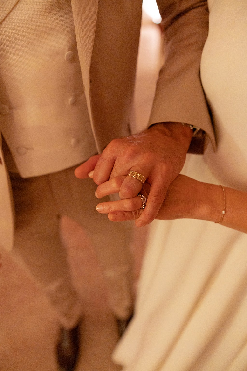 Married couple holding hands and showing their new rings