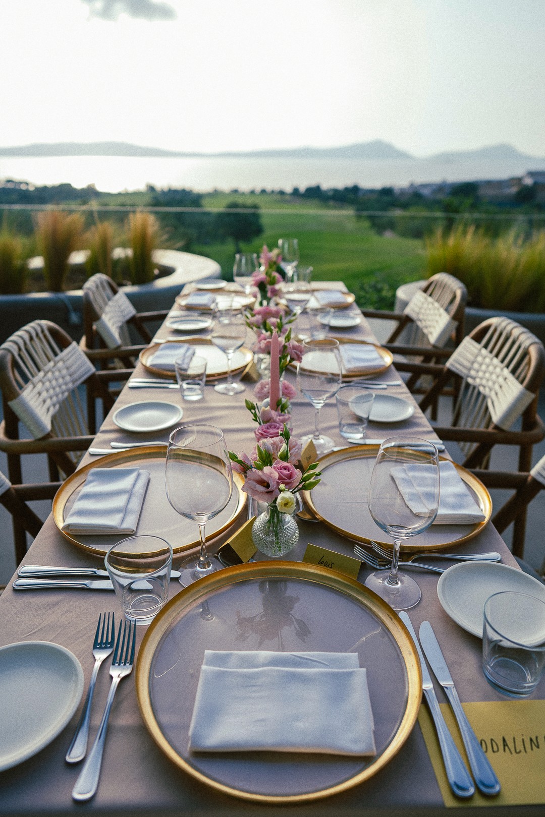 Panoramic view of luxury outdoor wedding reception tables set in a large Greek estate garden in Messinia