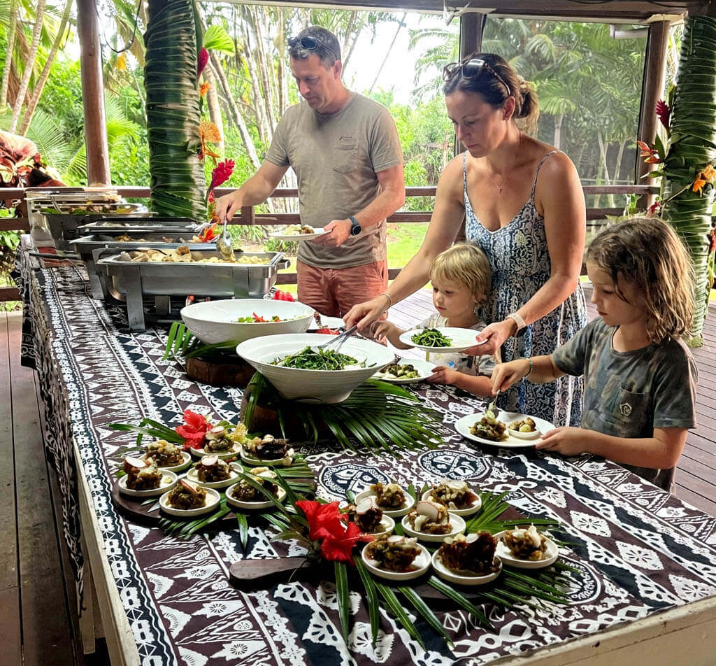 Family serving food from an outdoor buffet table at Uprising Beach Resort, Pacific Harbour, Fiji