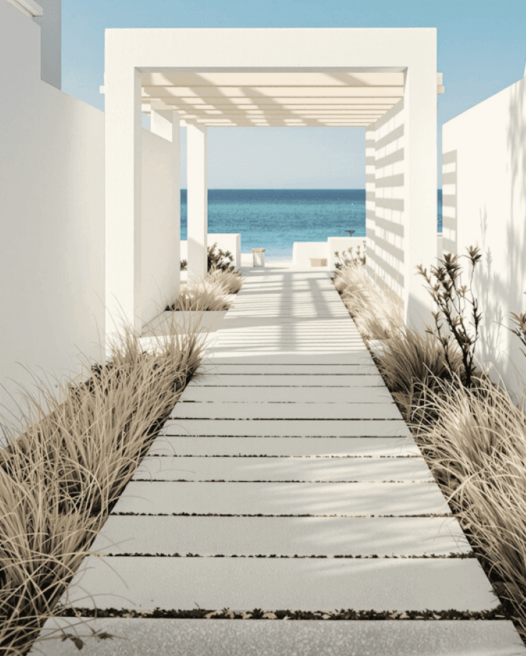 Modern white pathway with pergola leading to a seating area by the blue sea.