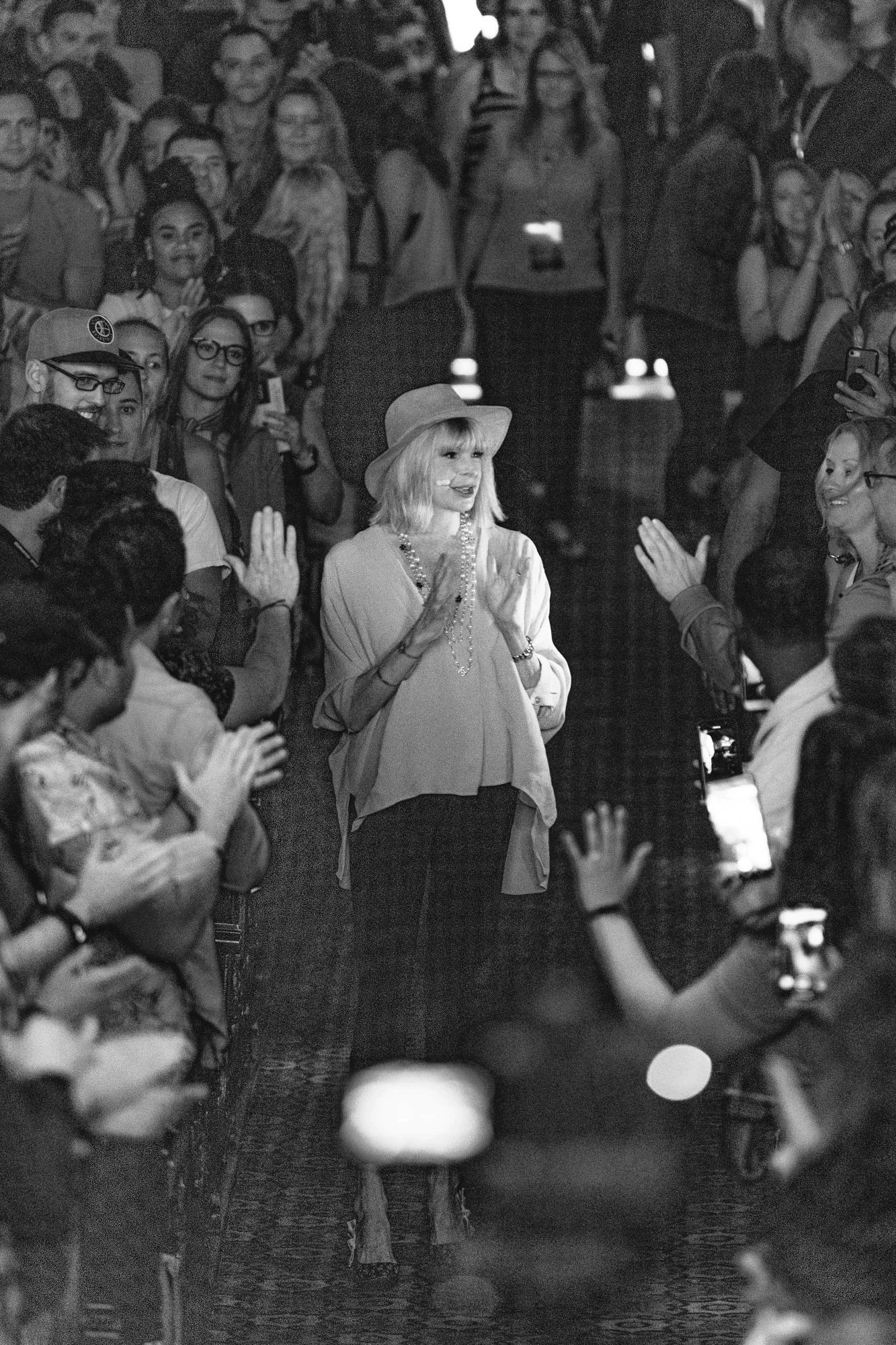 Woman walking through an applauding crowd. She represents symbol of inner power and transformation.