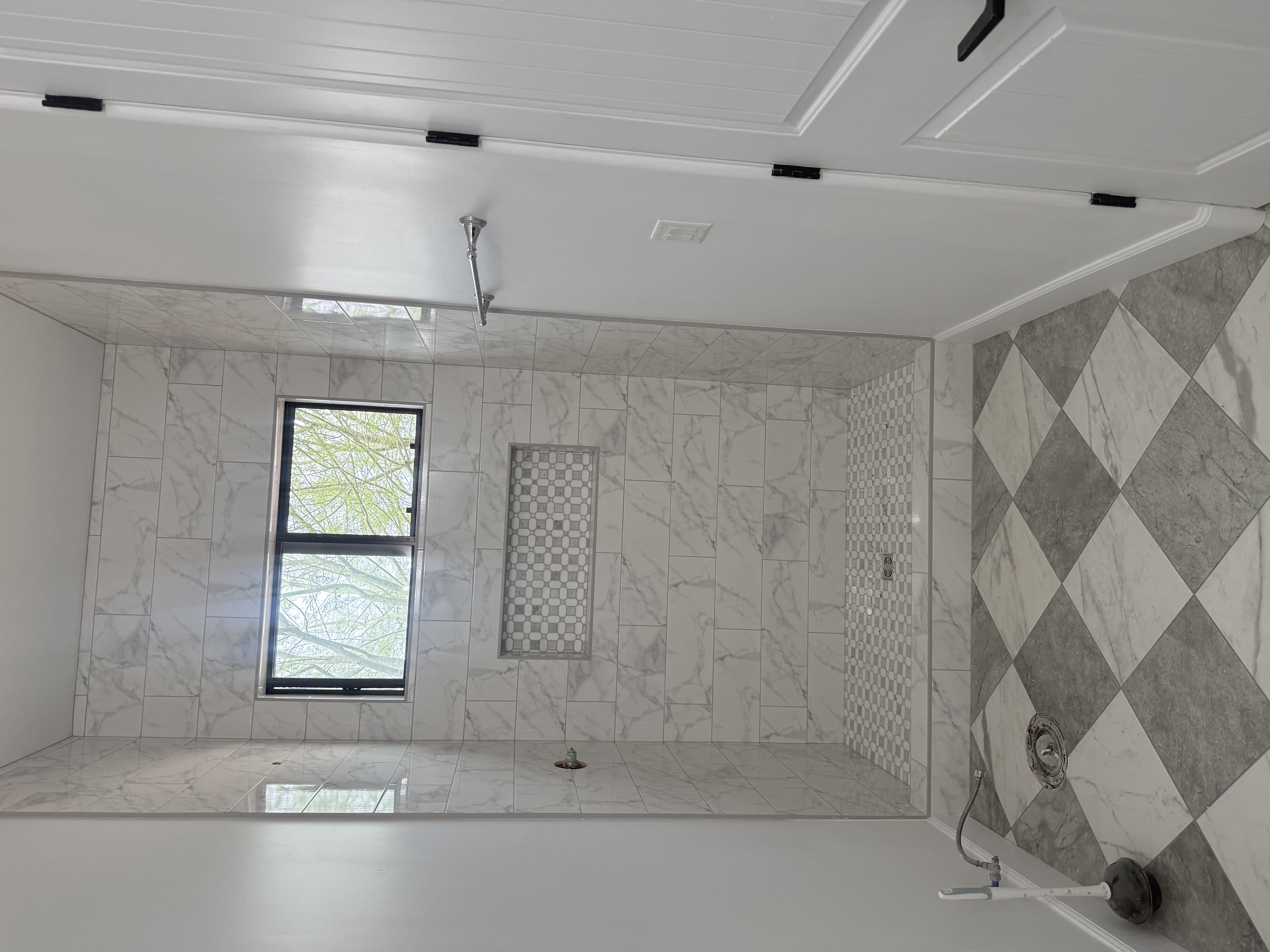 Luxurious bathroom vanity area with a dramatic wall featuring large format natural stone tiles in varying earthy tones and complex veining, serving as a striking backsplash above a double sink vanity.